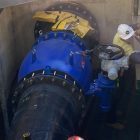 Large industrial gate valve installation with workers in confined space