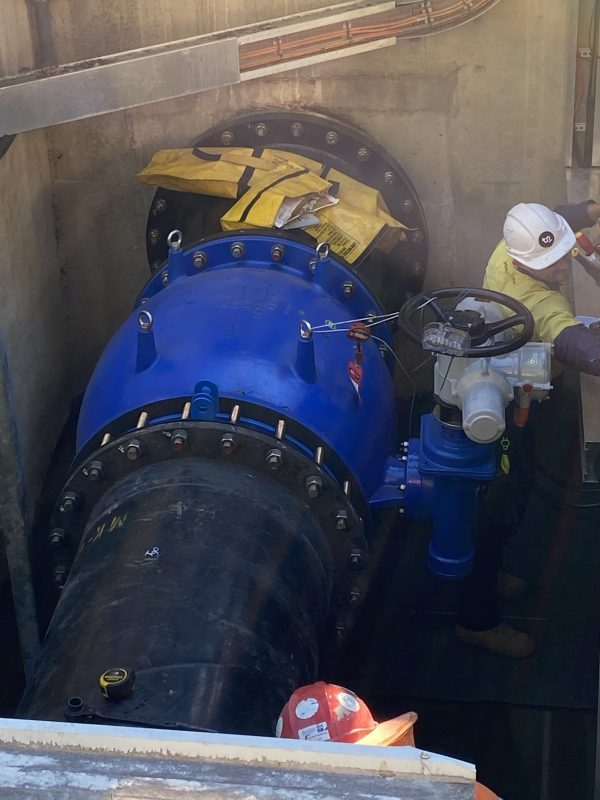 Large industrial gate valve installation with workers in confined space